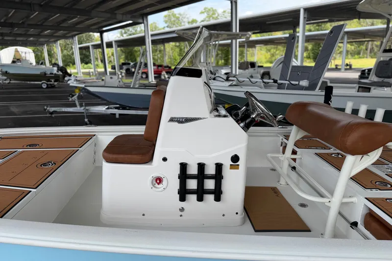 Slide: The Image of 2027 Avid 19 FSX boat interior with brown seating and steering console. - 18