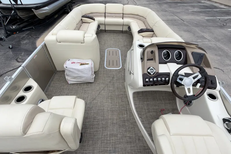 Slide: The Image of 2015 Bennington 2550 RSR pontoon boat interior with beige seating and steering console. - 22