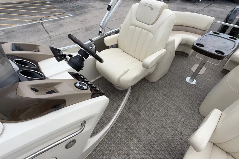 Slide: The Image of 2015 Bennington 2550 RSR boat interior with beige seating and steering console. - 23