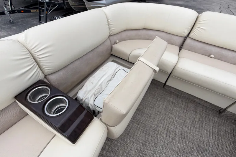 Slide: The Image of 2015 Bennington 2550 RSR boat interior with beige seating and cup holders. - 37