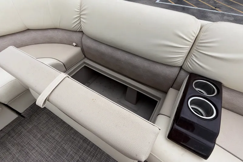 Slide: The Image of 2015 Bennington 2550 RSR boat interior with storage compartment and cup holders. - 35