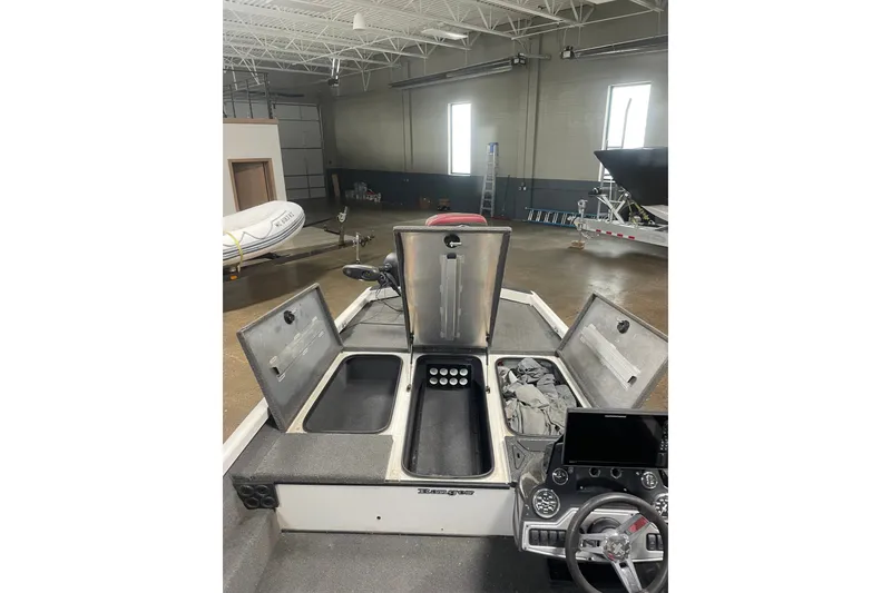 Slide: The Image of 2019 Ranger RT188 boat interior with open storage compartments in a warehouse setting. - 15