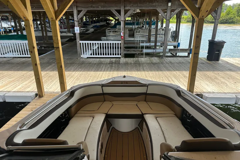 Slide: The Image of 2023 Yamaha Boats 275SDX docked in a covered marina, showcasing spacious seating. - 9
