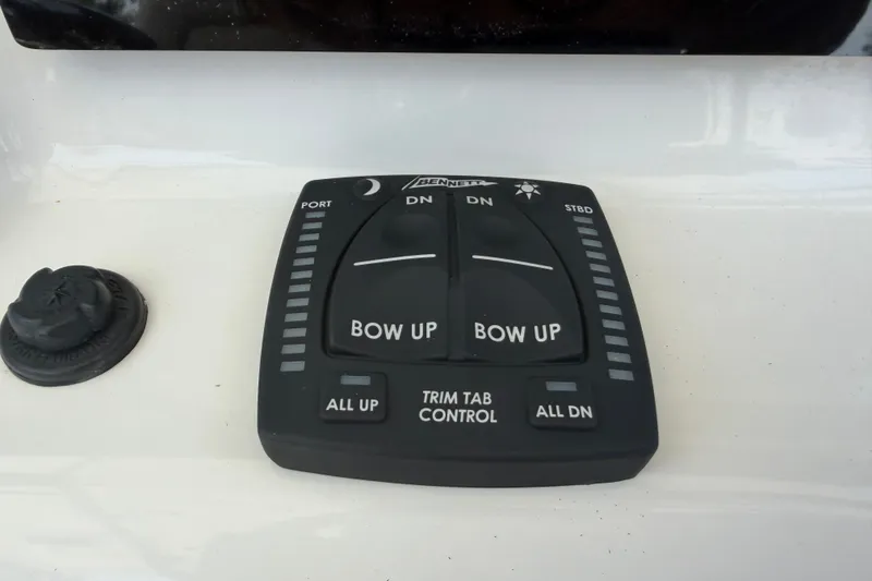 Slide: The Image of 2020 Sea Pro 239 Center Console trim tab control panel with bow adjustment buttons. - 21