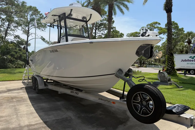 The Image of 2020 Sea Pro 239 Center Console boat on trailer, surrounded by palm trees. - 0