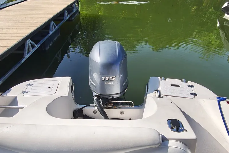 Slide: The Image of 2005 Vectra S-200 boat with Yamaha 115 outboard motor docked on calm water. - 13