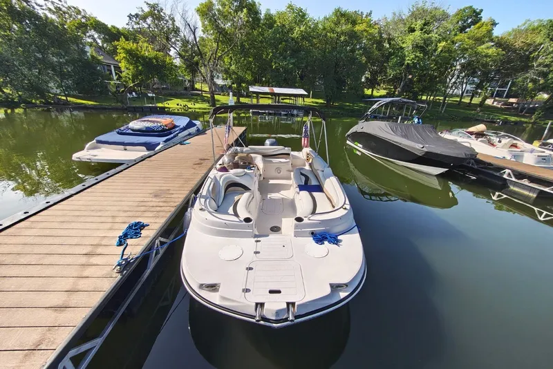 Slide: The Image of Boat docked on calm lake, surrounded by trees, featuring a 2005 Vectra S-200 model. - 3