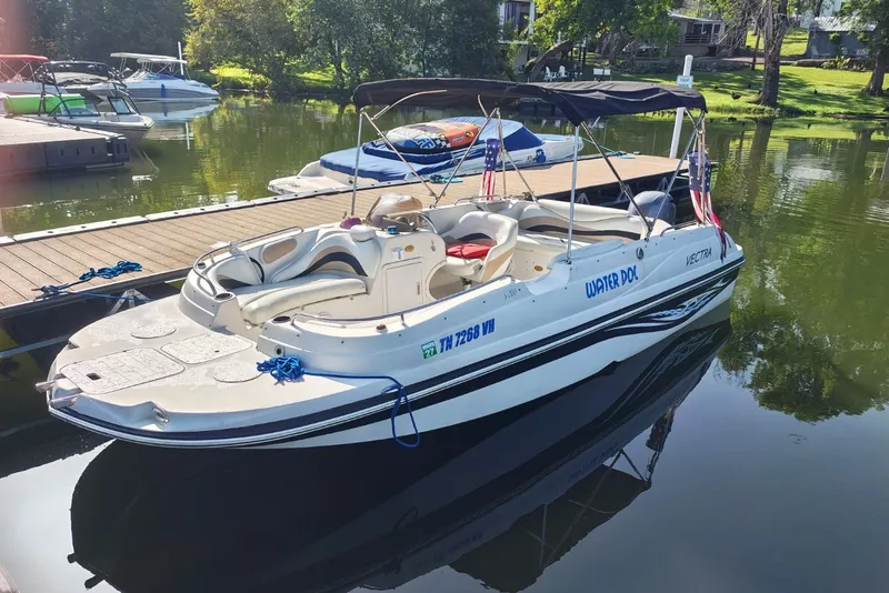 The Image of 2005 Vectra S-200 boat docked on a calm lake with lush greenery. - 1