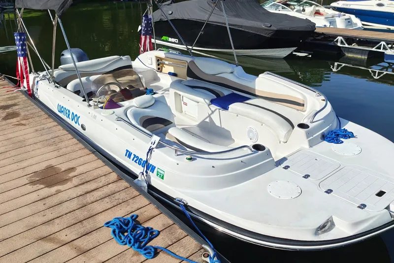 Slide: The Image of White Vectra S-200 boat docked, featuring spacious seating and American flag accents. - 6