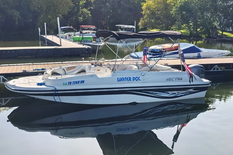 Slide: The Image of 2005 Vectra S-200 boat named "Water Doc" docked at a marina. - 2