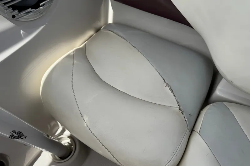 Slide: The Image of 2009 Tahoe Q4 SS boat seat with visible wear and stitching damage. - 12