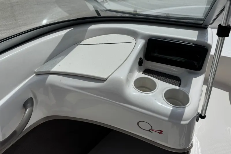 Slide: The Image of 2009 Tahoe Q4 SS boat interior with cup holders and storage compartment. - 17