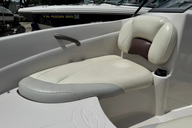 Slide: The Image of 2009 Tahoe Q4 SS boat seat with white and gray upholstery, featuring a cup holder. - 3
