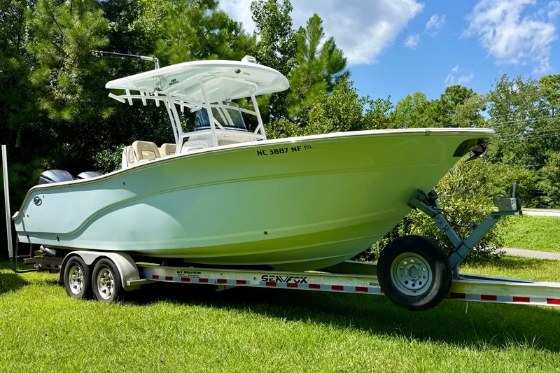 Slide: The Image of 2017 Sea Fox 288 Commander boat on trailer, parked on grass, surrounded by trees. - 6