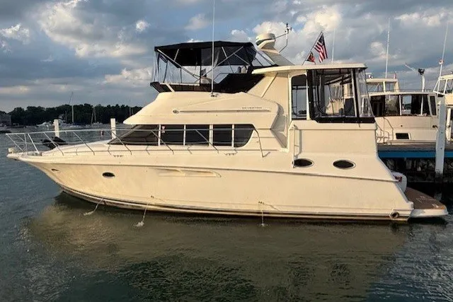 The Image of 2000 Silverton 422 Motor Yacht docked on calm water under cloudy sky. - 0