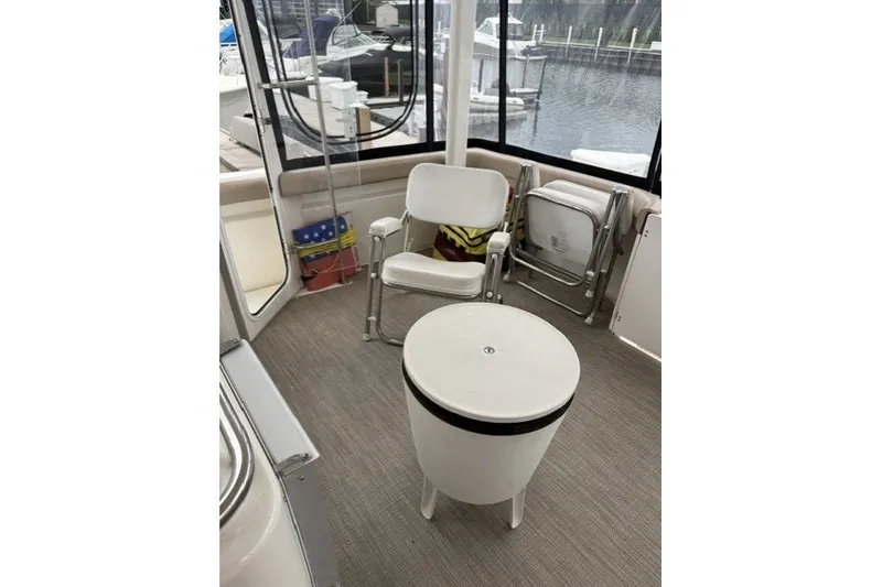 Slide: The Image of Interior of a 2000 Silverton 422 Motor Yacht with chairs and a small table. - 16