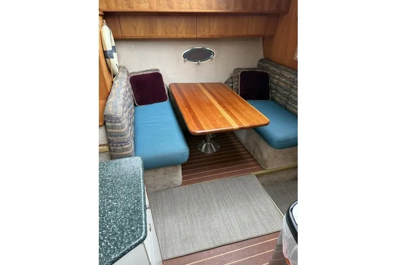 Slide: The Image of Interior of 2000 Silverton 422 Motor Yacht with wooden table and cushioned seating. - 18