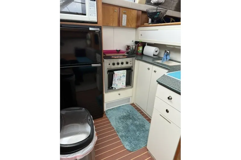 Slide: The Image of Compact kitchen in a 2000 Silverton 422 Motor Yacht with modern appliances and wood accents. - 17