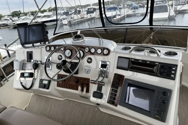 Slide: The Image of Cockpit of 2000 Silverton 422 Motor Yacht with navigation instruments and marina view. - 13
