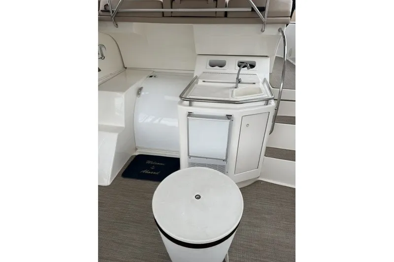 Slide: The Image of 2000 Silverton 422 Motor Yacht interior with sink, mini-fridge, and welcome mat. - 14