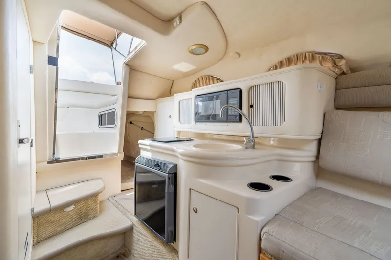 Slide: The Image of Interior of 2002 Sea Ray Sundancer 260 boat, featuring kitchenette and seating area. - 16