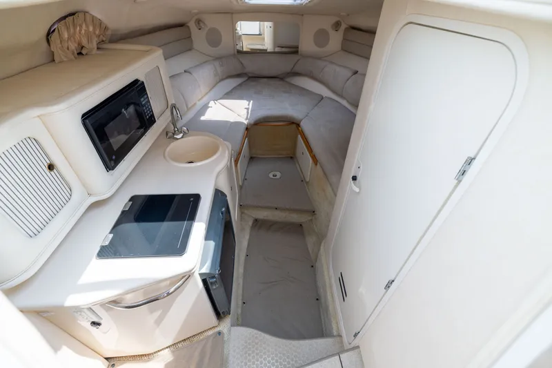 Slide: The Image of Interior of 2002 Sea Ray Sundancer 260, featuring kitchenette and cozy sleeping area. - 15