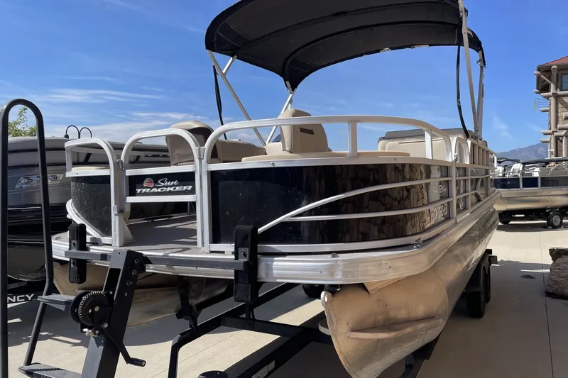 The Image of 2018 Bass Tracker pontoon boat with canopy on trailer, parked outdoors. - 0