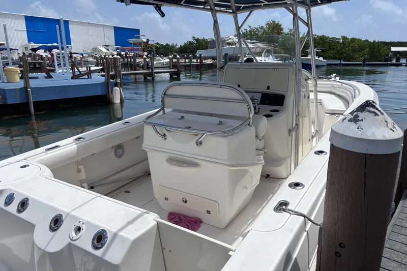 Slide: The Image of 2006 Boston Whaler Outrage 270 docked, showcasing spacious deck and seating area. - 28