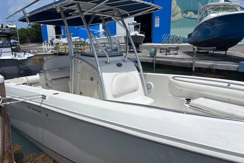 Slide: The Image of 2006 Boston Whaler Outrage 270 boat docked at marina, featuring sleek design and spacious seating. - 27