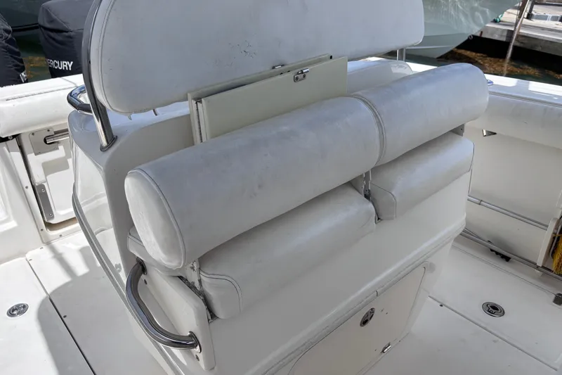 Slide: The Image of 2006 Boston Whaler Outrage 270 boat seating area with white cushioned seats. - 21