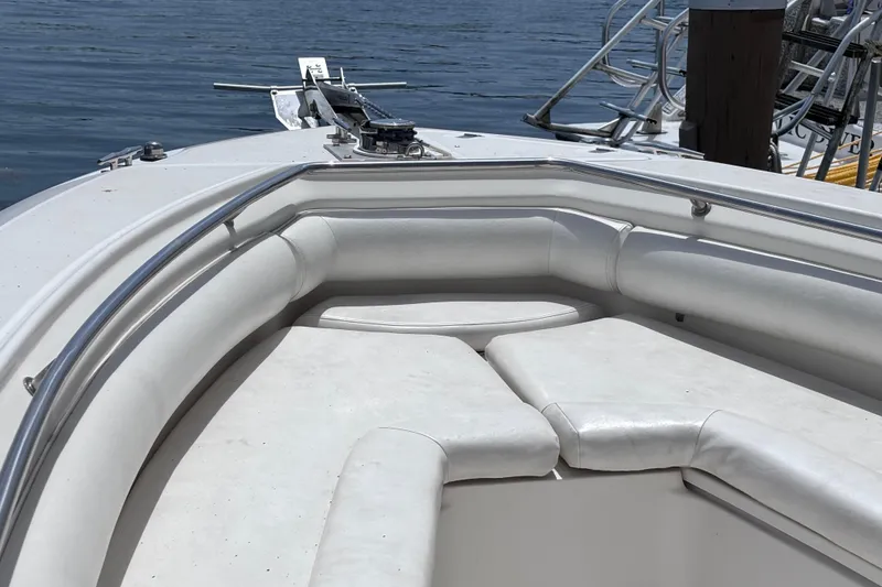Slide: The Image of 2006 Boston Whaler Outrage 270 boat with cushioned seating, docked by the water. - 19