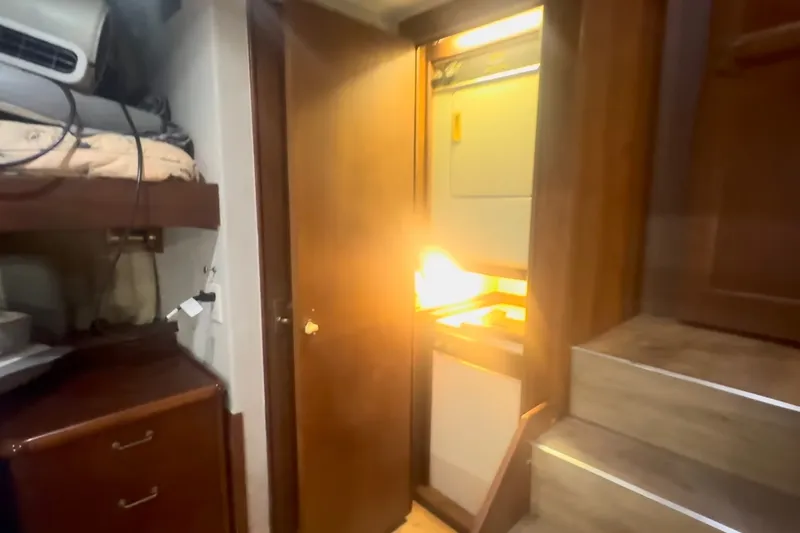 Slide: The Image of Interior of 1989 Ocean Yachts 48 Motor Yacht with open cabinet and stairs. - 50
