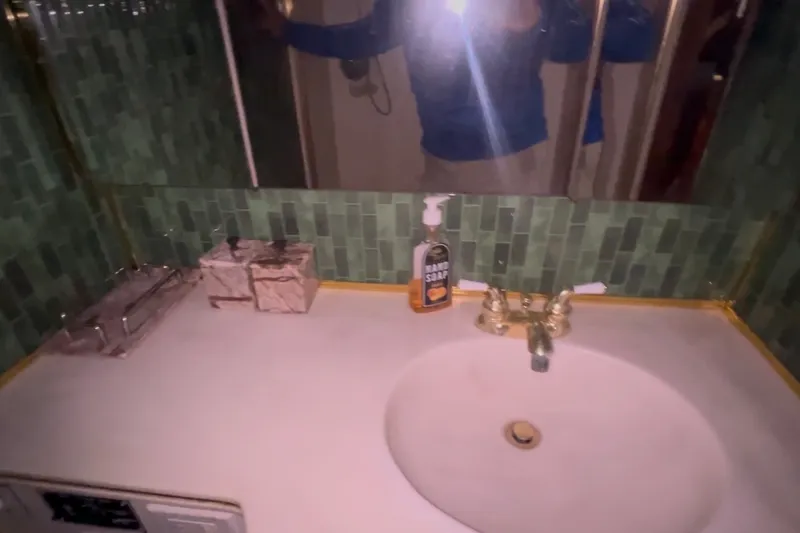 Slide: The Image of Bathroom sink area on 1989 Ocean Yachts 48 Motor Yacht with green tile backsplash. - 32