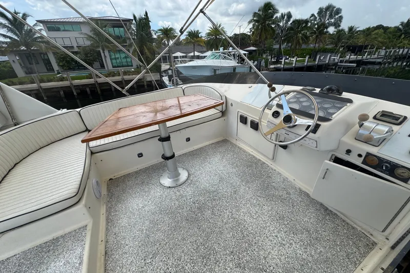 Slide: The Image of 1989 Ocean Yachts 48 Motor Yacht helm with seating and steering wheel, dockside view. - 106