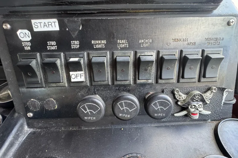 Slide: The Image of Control panel of a 1989 Ocean Yachts 48 Motor Yacht with switches and pirate emblem. - 81