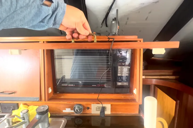 Slide: The Image of Hand opening cabinet with microwave on 1989 Ocean Yachts 48 Motor Yacht. - 14