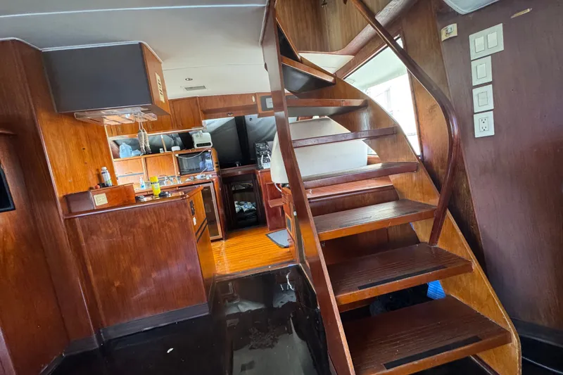 Slide: The Image of Interior of 1989 Ocean Yachts 48 Motor Yacht with wooden staircase and kitchen area. - 101