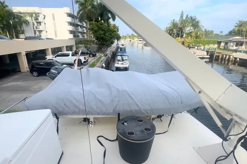 Slide: The Image of 1989 Ocean Yachts 48 Motor Yacht docked near waterfront, surrounded by parked vehicles and palm trees. - 42