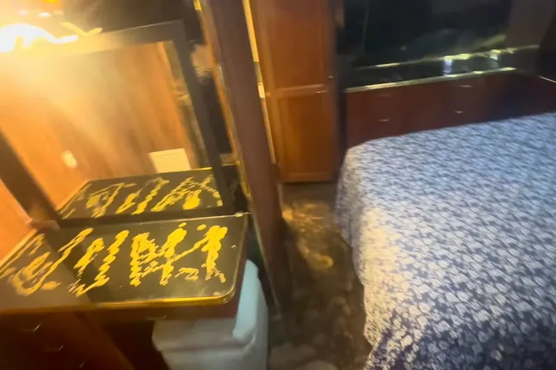 Slide: The Image of Interior of 1989 Ocean Yachts 48 Motor Yacht with floral bedspread and wooden cabinetry. - 27