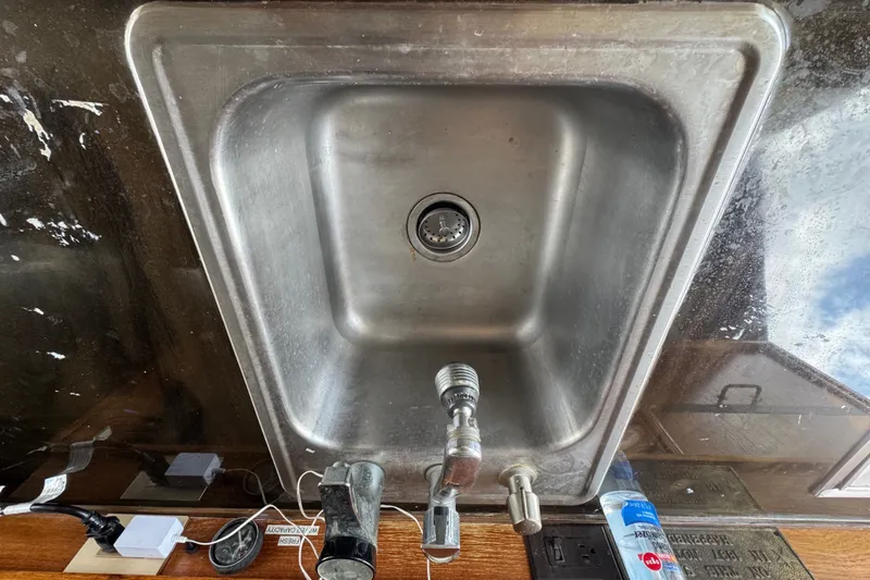Slide: The Image of Stainless steel sink on 1989 Ocean Yachts 48 Motor Yacht with faucet and countertop items. - 69