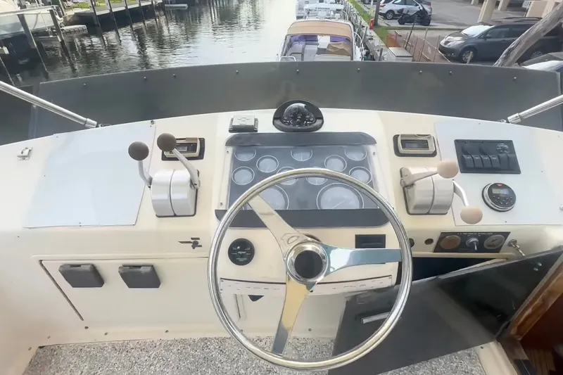 Slide: The Image of 1989 Ocean Yachts 48 Motor Yacht helm with steering wheel and control panel, dockside view. - 38