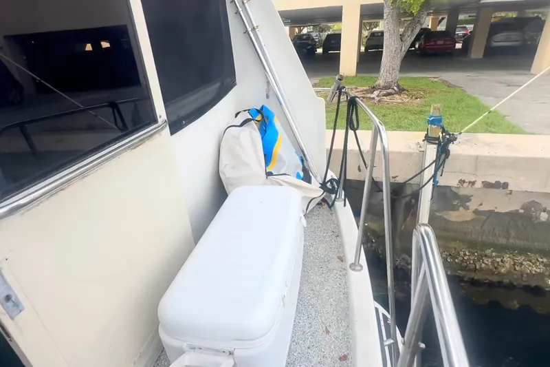 Slide: The Image of 1989 Ocean Yachts 48 Motor Yacht docked, featuring deck area with cooler and storage bag. - 25
