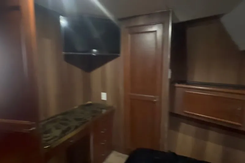 Slide: The Image of Interior of 1989 Ocean Yachts 48 Motor Yacht with wood paneling and mounted TV. - 47