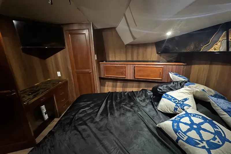 Slide: The Image of 1989 Ocean Yachts 48 Motor Yacht bedroom with wood paneling and nautical-themed pillows. - 90