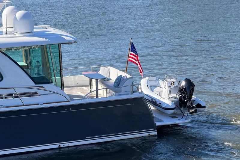 Slide: The Image of 2020 Sabre 58 Salon Express yacht with American flag on water. - 39