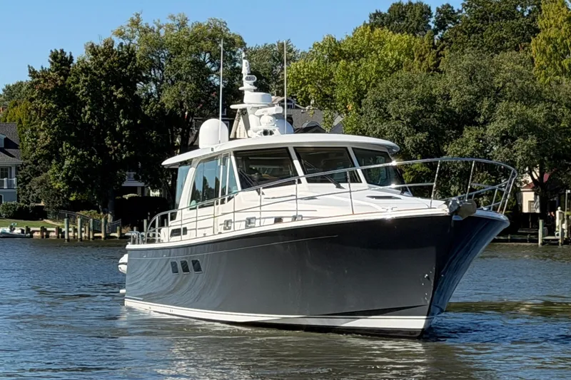 Slide: The Image of 2020 Sabre 58 Salon Express yacht cruising on a serene river near waterfront homes. - 41