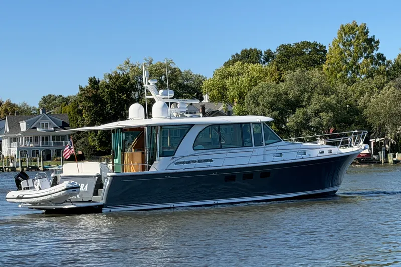 Slide: The Image of 2020 Sabre 58 Salon Express yacht cruising on a serene waterway with lush greenery. - 55