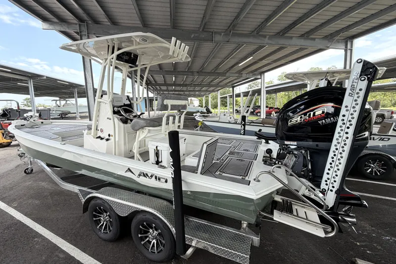 Slide: The Image of 2027 Avid 23 Mag boat with Yamaha engine on a trailer under a canopy. - 1