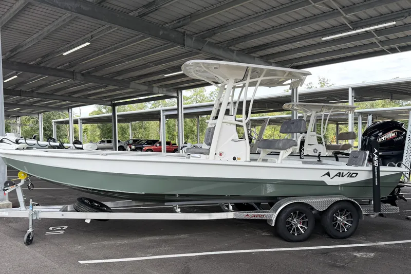 The Image of 2027 Avid 23 Mag boat on trailer under covered parking. - 0