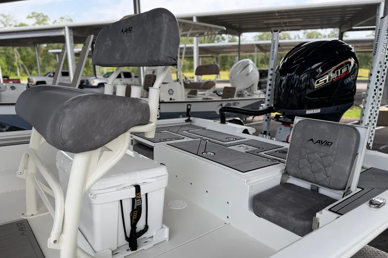 Slide: The Image of Avid 23 Mag 2027 boat interior with seating and Yamaha engine in a marina. - 10